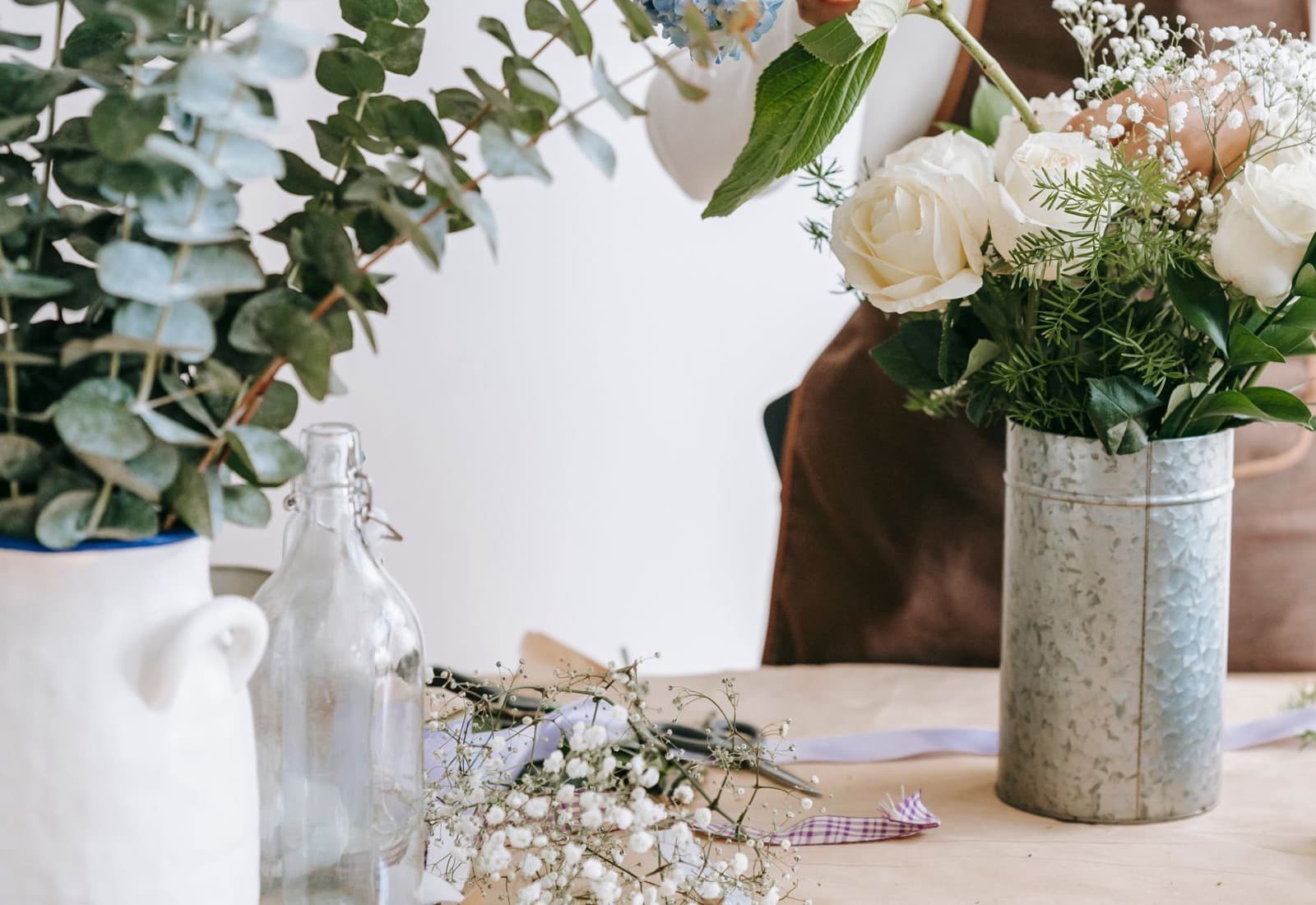 Établi d'atelier garni d'eucalyptus, de roses blanches et de gypsophile
